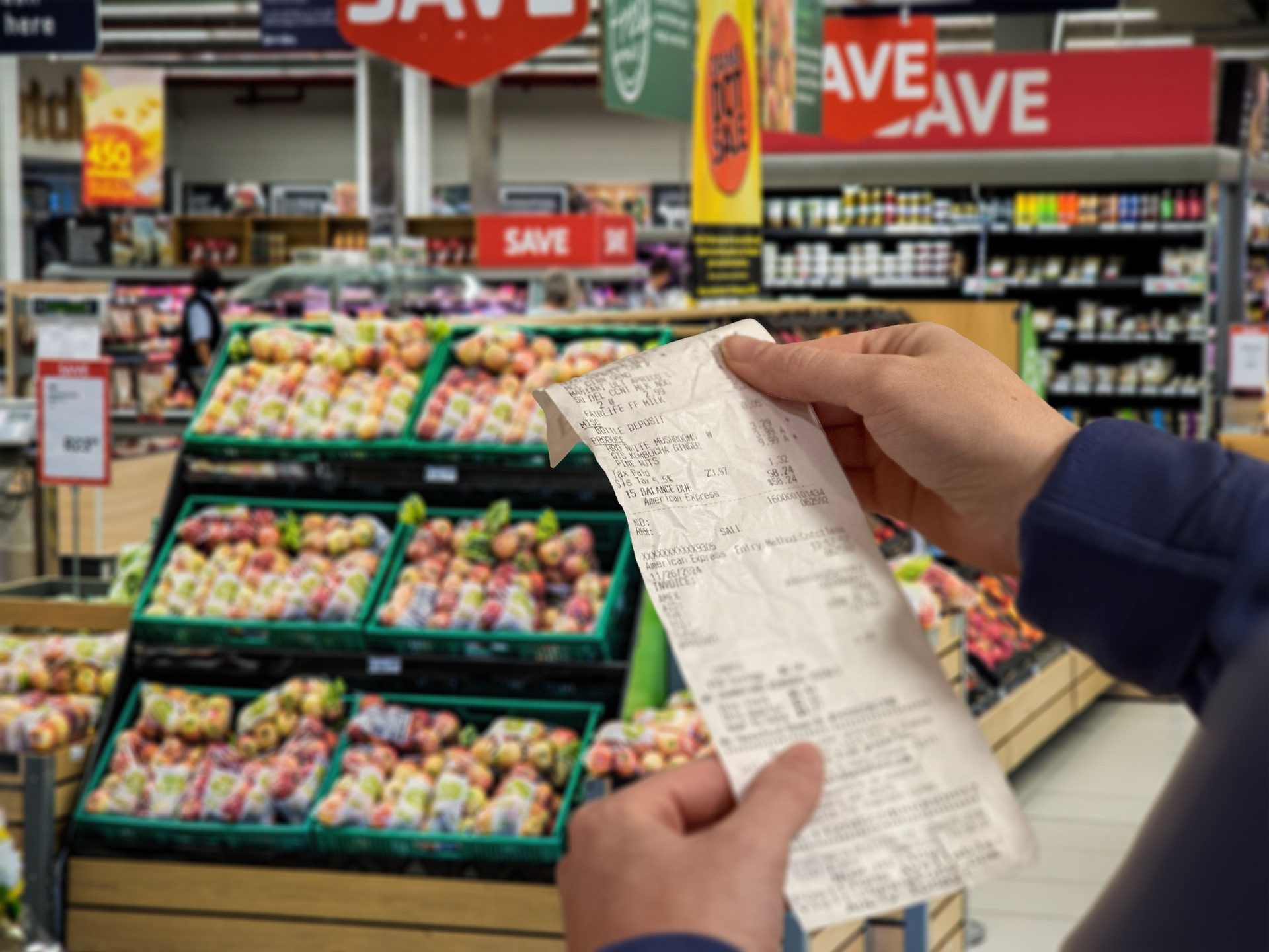 Woman shopping at a grocery store and checking her receipt